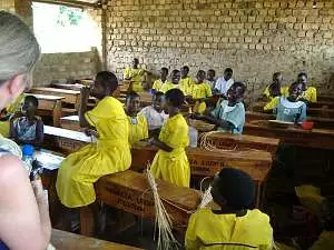 Schoolchildren, many of them in bright yellow uniforms, in their classroom at Champona school